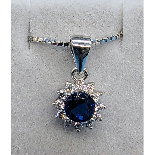 404 - Silver round halo cluster pendant set with round blue cz and halo of white round cz on a silver chai... 