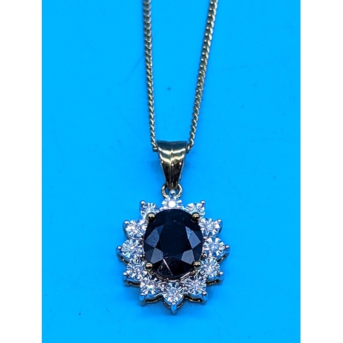 764 - 9ct yellow gold oval sapphire and diamond cluster pendant on a gold coated silver chain.  Sapphire 1... 