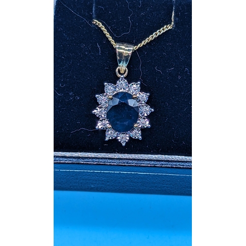 764 - 9ct yellow gold oval sapphire and diamond cluster pendant on a gold coated silver chain.  Sapphire 1... 