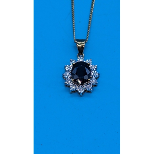 764 - 9ct yellow gold oval sapphire and diamond cluster pendant on a gold coated silver chain.  Sapphire 1... 