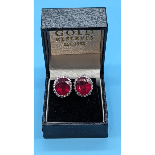 718 - 18ct white gold ruby and diamond cluster earrings.  Rubies (glass filled) 8.71ct.  Diamonds 0.80ct. ... 