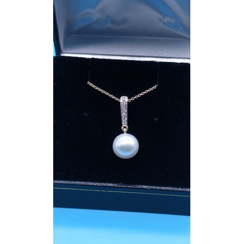 761 - 9ct yellow gold round freshwater pearl and diamond pendant on a 9ct yellow gold chain.  Diamonds 0.0... 