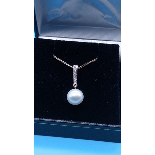 761 - 9ct yellow gold round freshwater pearl and diamond pendant on a 9ct yellow gold chain.  Diamonds 0.0... 