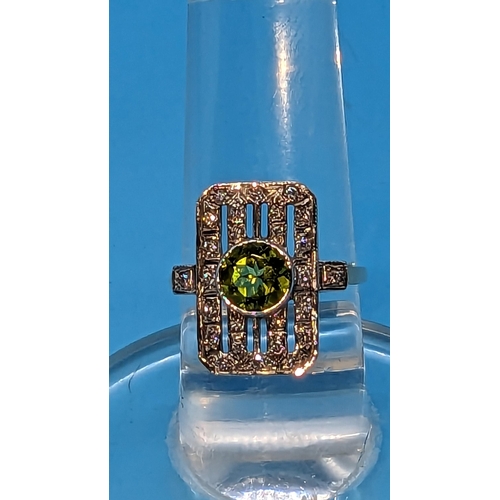 724 - 9ct white and yellow gold peridot and diamond art deco style ring.  Peridot 0.85ct.  Diamonds 0.26ct... 