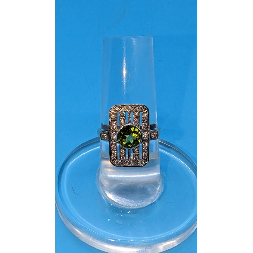 724 - 9ct white and yellow gold peridot and diamond art deco style ring.  Peridot 0.85ct.  Diamonds 0.26ct... 