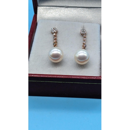 719 - Pair 9ct rose gold pearl and diamond drop earrings.  Diamonds 0.17ct.  Boxed