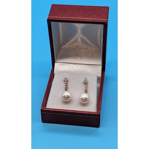 719 - Pair 9ct rose gold pearl and diamond drop earrings.  Diamonds 0.17ct.  Boxed