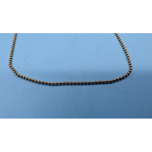 799 - A 9ct (Stamped 375) Yellow Gold Bead Necklace. 50 cm.