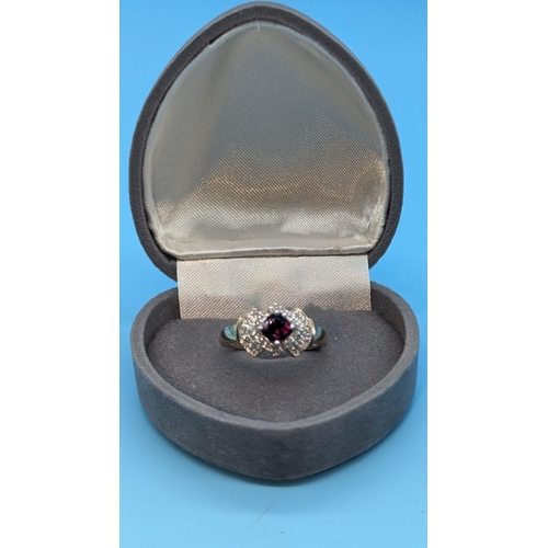 473 - 9k yellow gold halo ring with garnets and diamonds. Garnet 0.50ct approx. Diamonds 0.32ct approx.   ... 