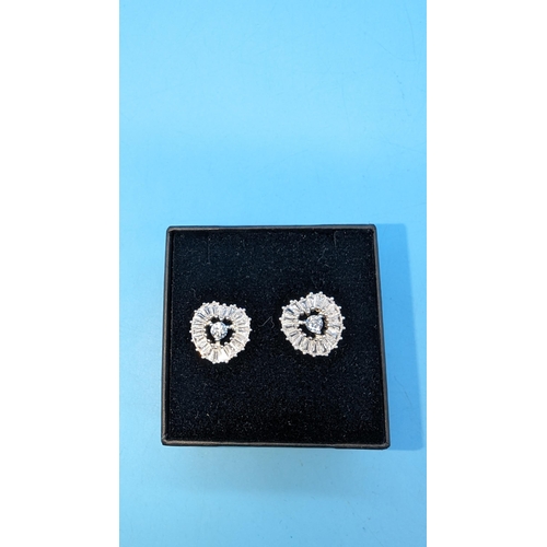 518 - Pair silver heart shaped earrings set with round and tapered baguette cut cubiz zirconia