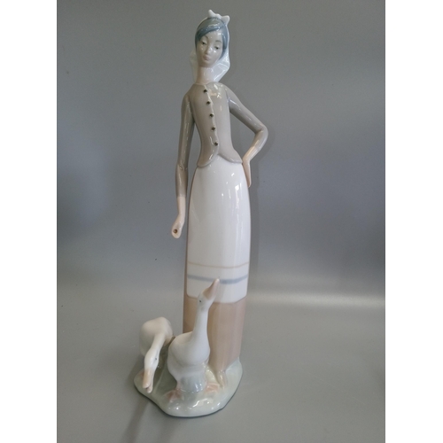 696 - 2 Lladro Figurines, one nun and a girl with geese.