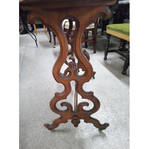 394 - Carved Occasional Table with Walnut Veneer Top and Castors. 
75cm H x 90cm L x 41cm W.