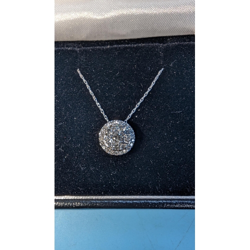 585 - Round brilliant diamond cluster pendant set in 10ct white gold on a 10ct white gold chain.  Boxed.  ... 