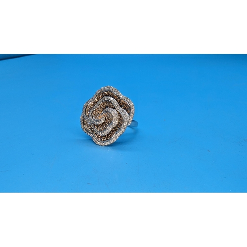 595 - Large 9ct white gold and rose swirling floral ring set with yellow and white diamonds.  Approx. 1.50... 