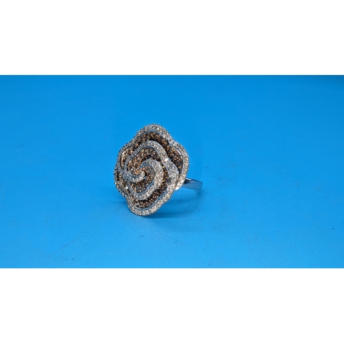 595 - Large 9ct white gold and rose swirling floral ring set with yellow and white diamonds.  Approx. 1.50... 