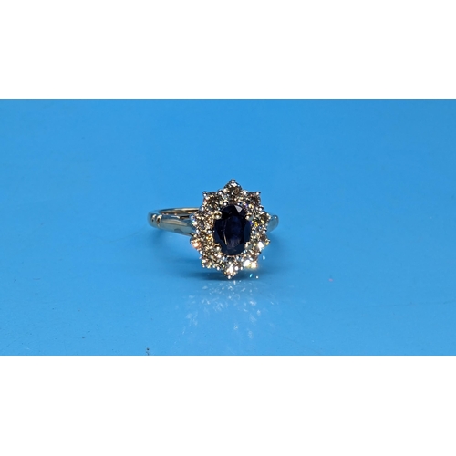 590 - 9ct yellow gold ring set with oval sapphire and halo of round brilliant cut diamonds.  Diamonds 0.81... 