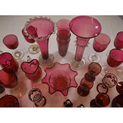 70 - A GROUP OF 19TH CENTURY CRANBERRY GLASS WARES, including two trumpet vases, jugs, bowl and stemmed g... 