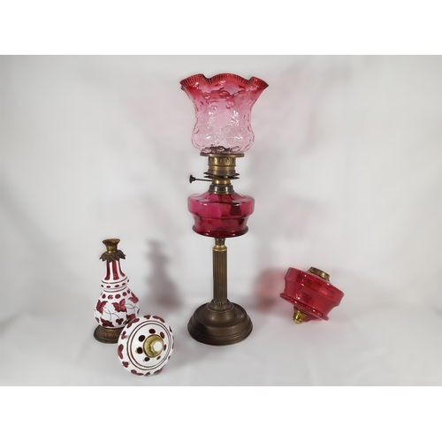 143 - A 19TH CENTURY BRASS AND CRANBERRY GLASS OIL LAMP, with fluted pillar and crimped cranberry tinged s... 