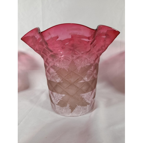 158 - A GROUP OF NINE CRANBERRY TINGED GLASS LAMP SHADES, various styles and sizes, some with etched decor... 