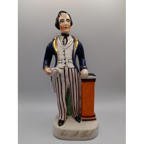 154 - A MID 19TH CENTURY STAFFORDSHIRE FIGURE OF SIR ROBERT PEEL, modelled standing next to a pedestal hol... 