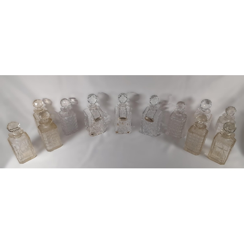 165 - A GROUP OF TWELVE VINTAGE CUT GLASS DECANTERS, all of square form with stoppers
25 cm high max