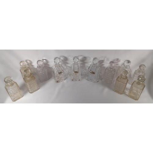 165 - A GROUP OF TWELVE VINTAGE CUT GLASS DECANTERS, all of square form with stoppers
25 cm high max