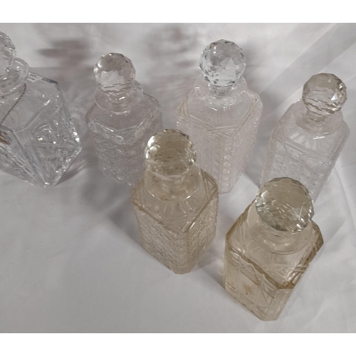 165 - A GROUP OF TWELVE VINTAGE CUT GLASS DECANTERS, all of square form with stoppers
25 cm high max