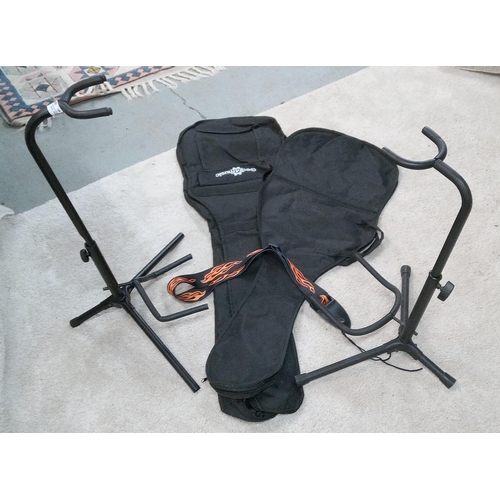 354 - 2 Guitar Stands, 2 Guitar Soft Cases and a Guitar Strap.