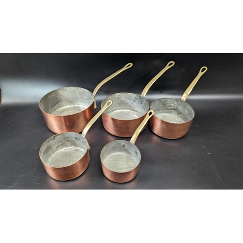 604 - A Set of Brass Handled Copper Saucepans.