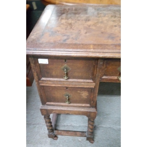 779 - An Antique Oak Desk with well worn leather top. 5 Drawers and Barley Twist Legs on Castors with Bras... 