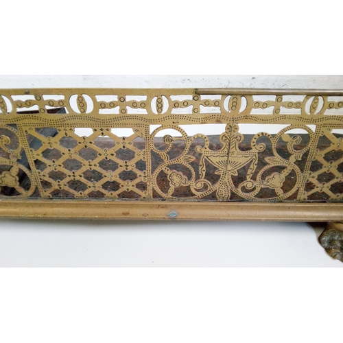 735 - An Antique pierced brass fender with Lions feet and rounded corners.