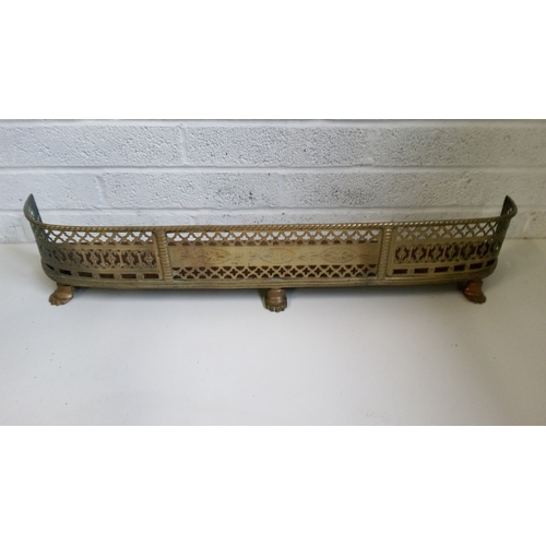 736 - An antique Brass fireplace fender with pierced design and Claw feet.
19cm high 105 wide 19 deep.