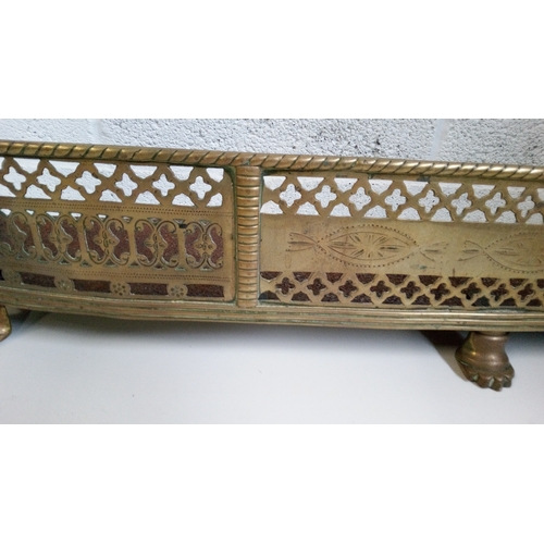 736 - An antique Brass fireplace fender with pierced design and Claw feet.
19cm high 105 wide 19 deep.