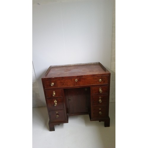 756 - A 7 Drawer Mahogany Desk With Brass Handles, Centre Cupboard And Brass Galley.
80cm High,82cm Wide,4... 