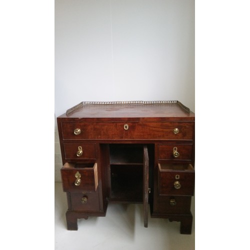 756 - A 7 Drawer Mahogany Desk With Brass Handles, Centre Cupboard And Brass Galley.
80cm High,82cm Wide,4... 