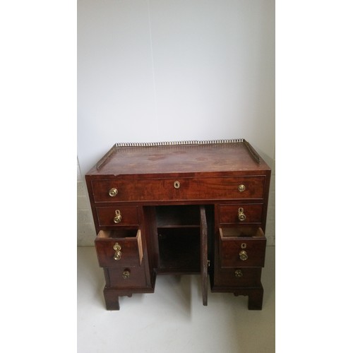 756 - A 7 Drawer Mahogany Desk With Brass Handles, Centre Cupboard And Brass Galley.
80cm High,82cm Wide,4... 