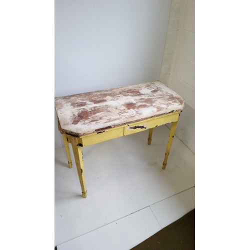 771 - A Yellow Painted Fold Over  Table On Tapered legs.
75cm High,92cm Wide,46cm Deep