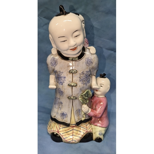 64 - An Oriental figurine of a man playing with children -32cm tall