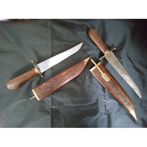 893 - Two Daggers with Carved Handles and Sheaths with Brass Fittings.