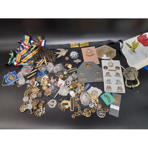 652 - A Large Selection of Military Badges, Ribbons, Gun  Casings, Coins and More.