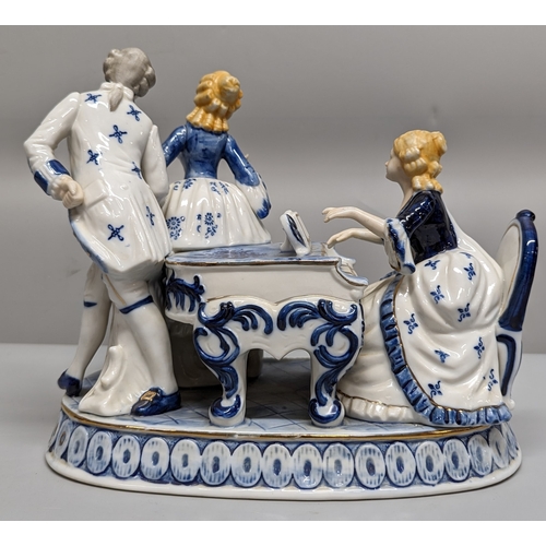 75 - A ceramic ornament of Regency figurines playing a piano - 23 x 28 x 15cm