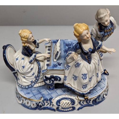 75 - A ceramic ornament of Regency figurines playing a piano - 23 x 28 x 15cm