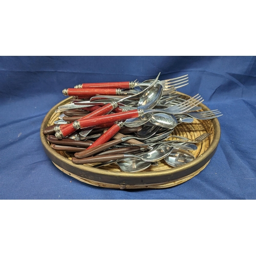 704 - A Selection of stainless steel Italian cutlery and others in basket.   From the country estate.