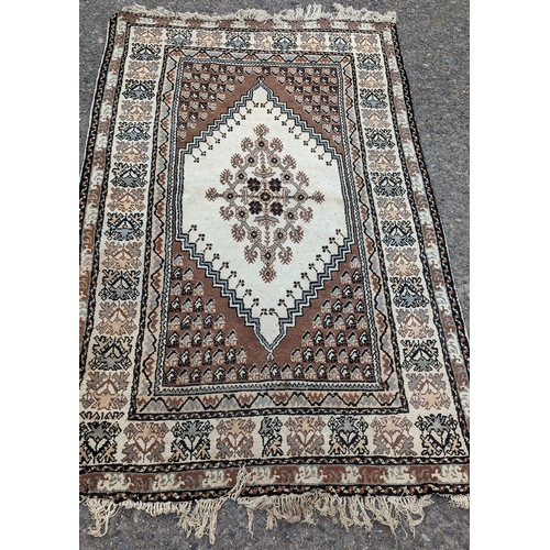 864 - Wool rug in cream and browns - work and torn in one corner as pictured