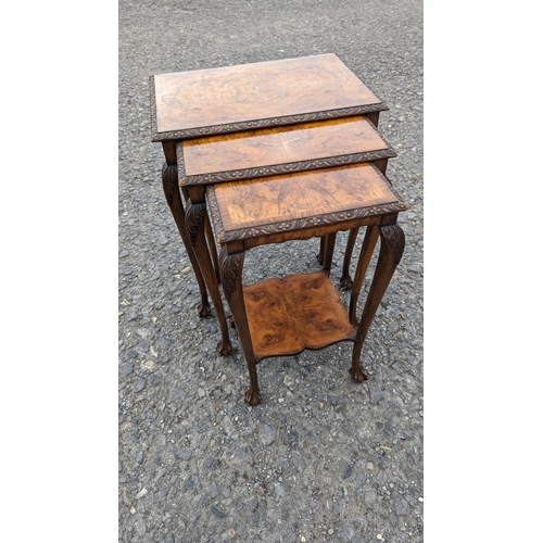 1240 - A Nest of Carved and Cross Cut Veneered Tables with Claw and Ball Feet