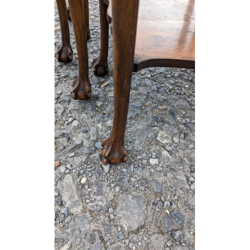 1240 - A Nest of Carved and Cross Cut Veneered Tables with Claw and Ball Feet