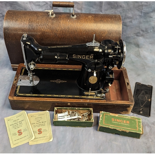 515 - A cased singer sewing machine with tool box and instruction booklets