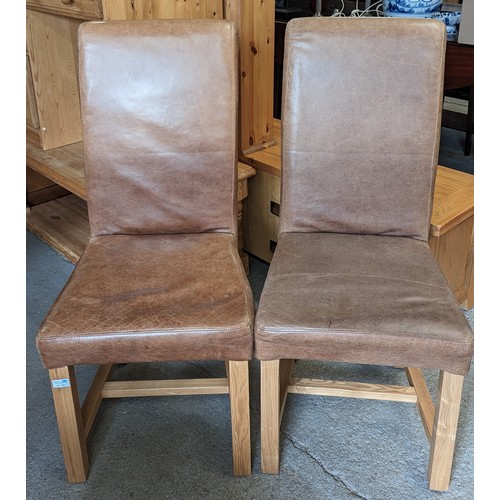 1119 - A pair of high backed leather chairs