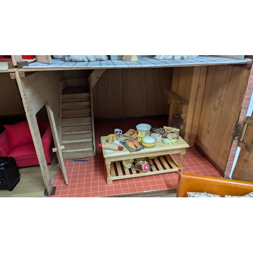 144 - A Dolls House with a Large Quantity of Furniture and accessories. 63.5cm Wide and 55cm High, 32cm De... 