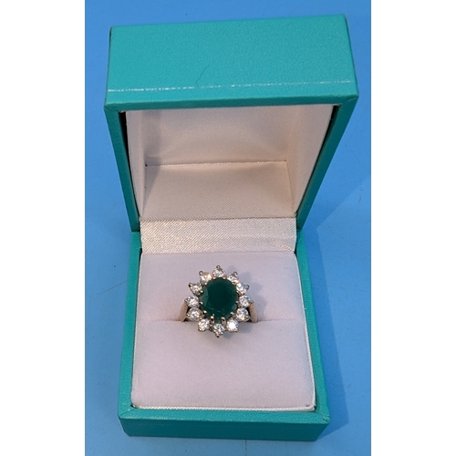 702 - An Emerald Ring Surrounded By Clear Stones - 9ct Gold Size L. 3.79gms Total Weight